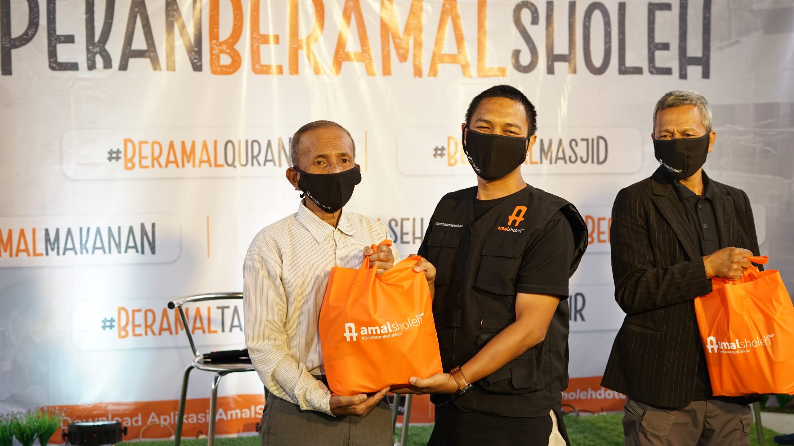 nur roni (ceo amalsholeh) menyerahkan sembako kepada masyarakat